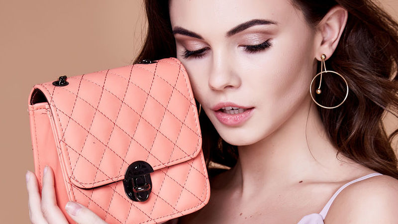 Portrait of beautiful pretty woman makeup face care cosmetic cream lotion plastic surgery accessory bag dress clothes wear style glamour lady mascara beauty salon organic skin brunette hair jewelry.